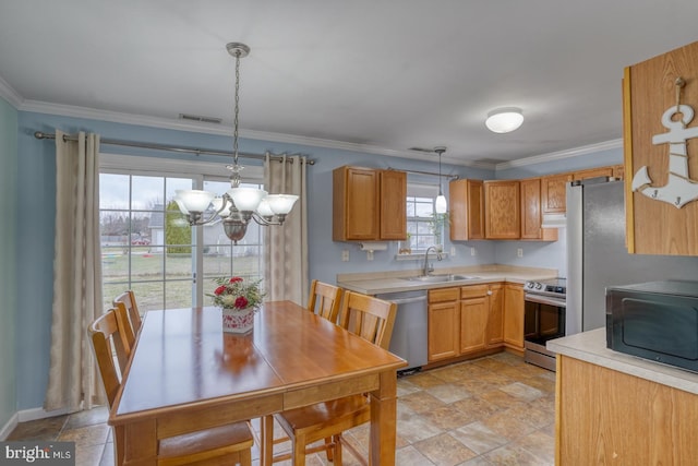 kitchen with sink, an inviting chandelier, crown molding, pendant lighting, and appliances with stainless steel finishes