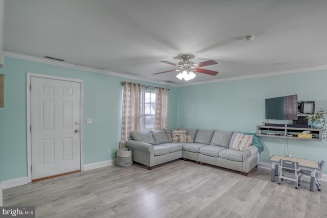 living room featuring light hardwood / wood-style floors, ceiling fan, and crown molding