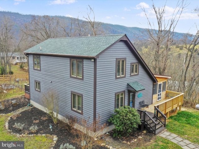 view of property exterior featuring a deck with mountain view