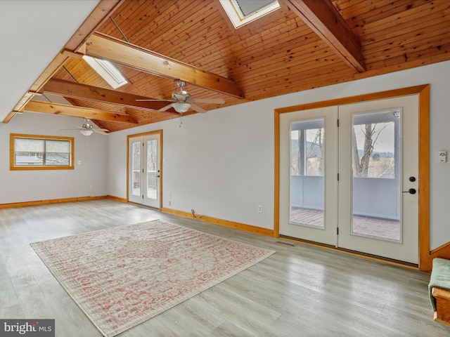 spare room with french doors, vaulted ceiling with skylight, ceiling fan, wooden ceiling, and light hardwood / wood-style floors