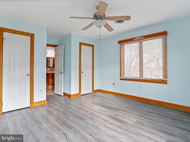 unfurnished bedroom with connected bathroom, ceiling fan, and light wood-type flooring