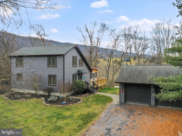 view of side of property featuring a lawn and a deck with mountain view