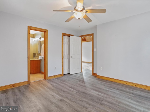 unfurnished bedroom featuring ceiling fan, light wood-type flooring, and connected bathroom