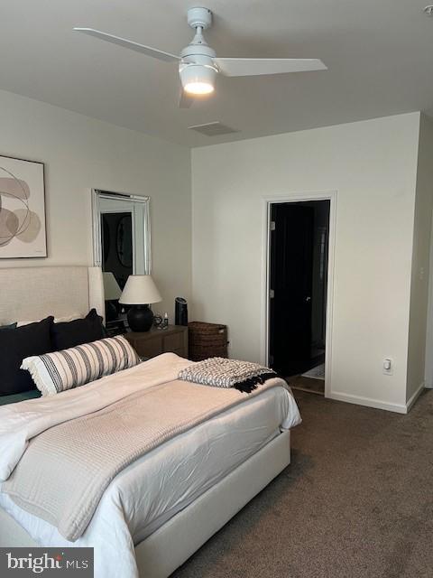 bedroom with ceiling fan and dark carpet