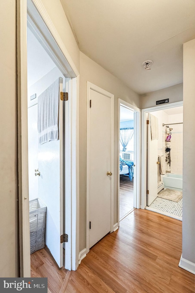 hallway featuring light wood-type flooring and a baseboard heating unit