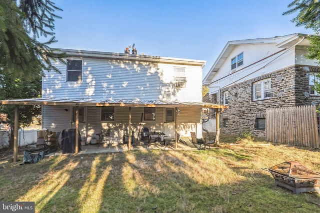 back of house featuring a yard, a fire pit, and a patio area