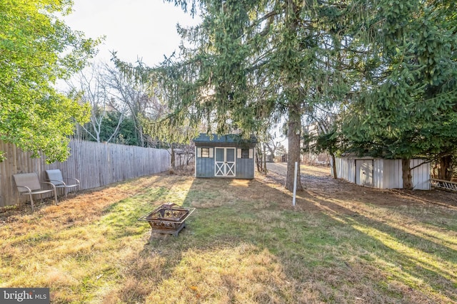 view of yard featuring a shed and a fire pit