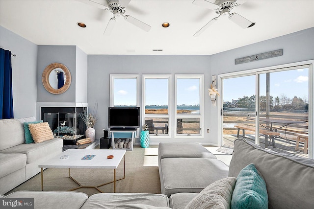 living room with ceiling fan and light colored carpet