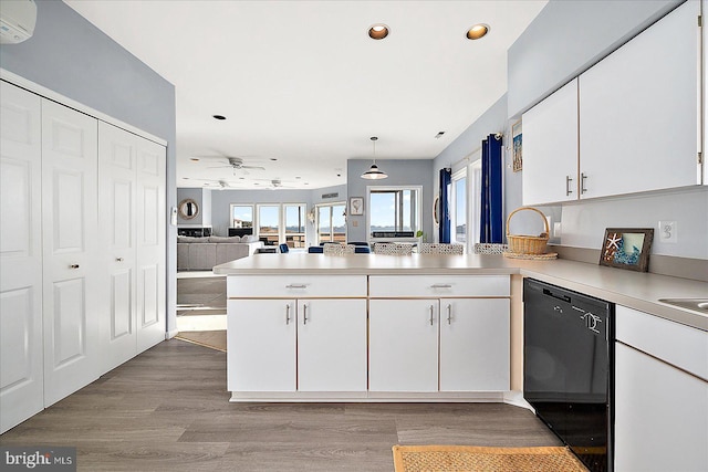 kitchen with kitchen peninsula, black dishwasher, light hardwood / wood-style floors, white cabinetry, and hanging light fixtures