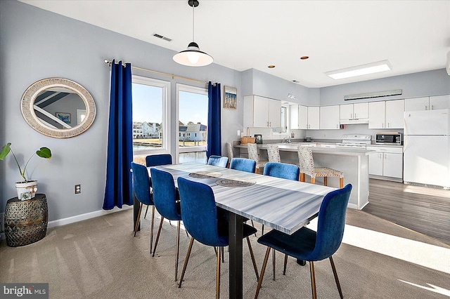 dining space featuring light colored carpet and sink