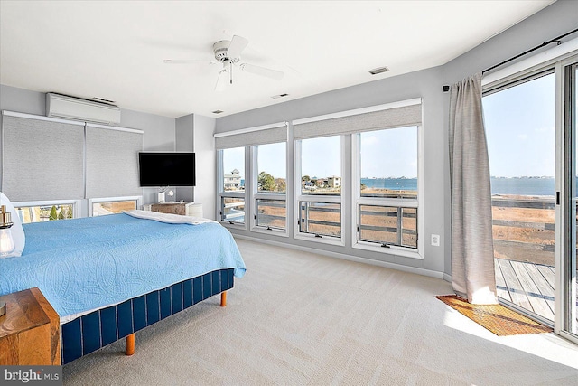 bedroom featuring an AC wall unit, multiple windows, ceiling fan, and light carpet