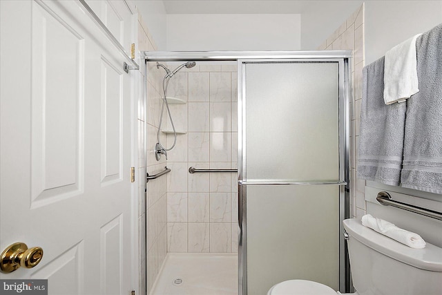 bathroom featuring toilet and an enclosed shower