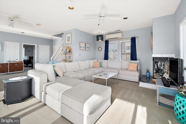 carpeted living room with a wall unit AC and ceiling fan