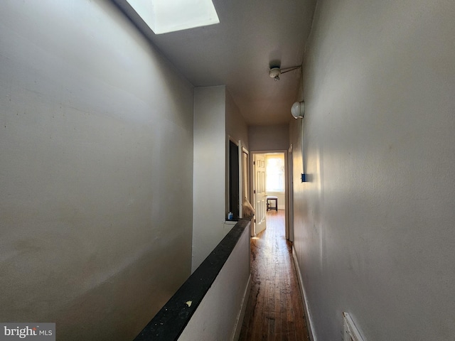 hallway with a skylight and hardwood / wood-style floors