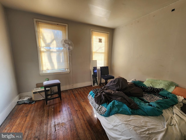 bedroom featuring multiple windows and dark wood-type flooring