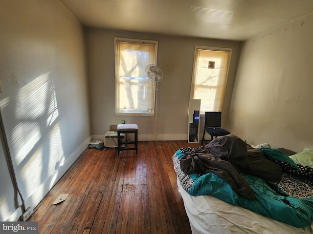 bedroom with dark hardwood / wood-style floors and multiple windows