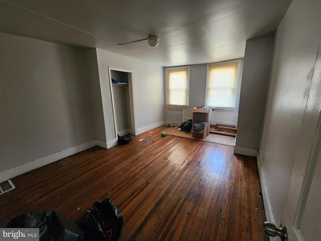 unfurnished bedroom featuring ceiling fan and dark wood-type flooring