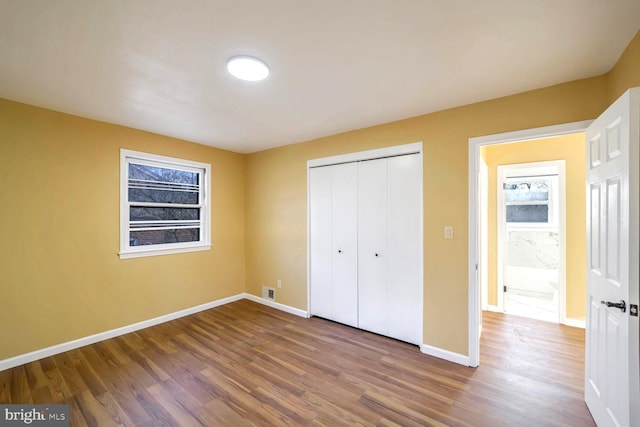 unfurnished bedroom featuring wood-type flooring and a closet