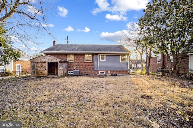 rear view of house featuring central AC and a shed