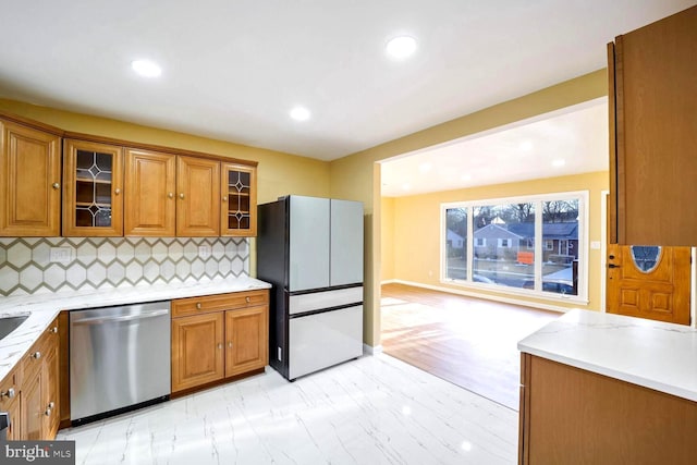 kitchen with decorative backsplash, stainless steel dishwasher, and fridge