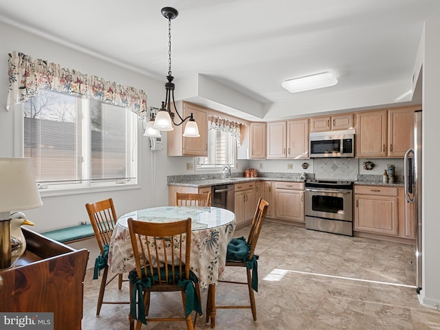 kitchen featuring decorative backsplash, light stone countertops, stainless steel appliances, and decorative light fixtures