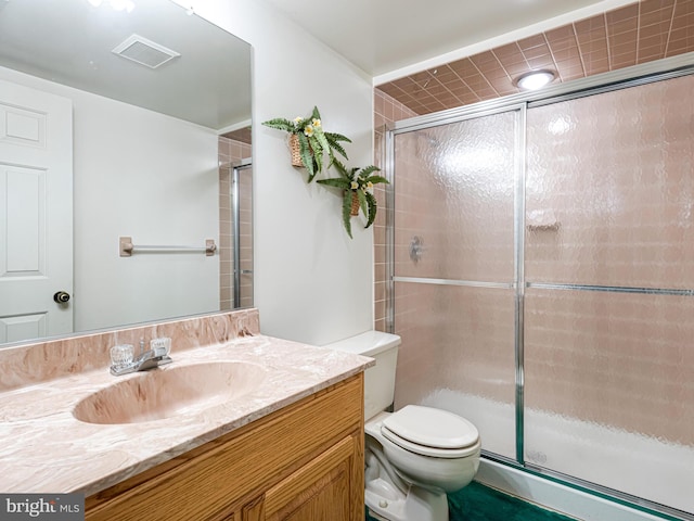 bathroom with vanity, an enclosed shower, and toilet