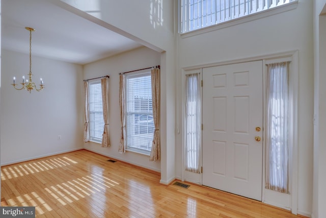 foyer entrance featuring a chandelier and light hardwood / wood-style floors