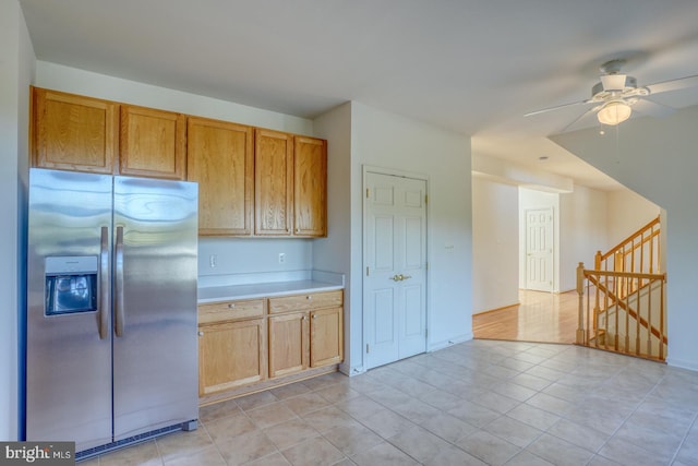 kitchen with stainless steel fridge, light tile patterned floors, and ceiling fan