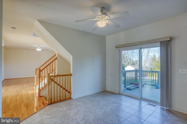 tiled spare room featuring ceiling fan