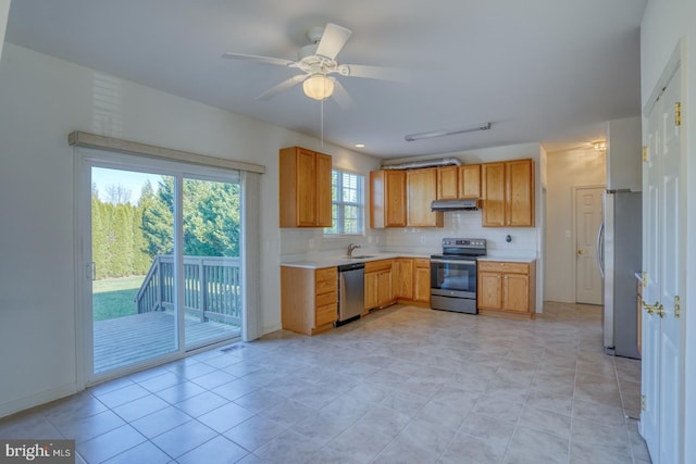 kitchen with ceiling fan, sink, tasteful backsplash, light tile patterned floors, and appliances with stainless steel finishes