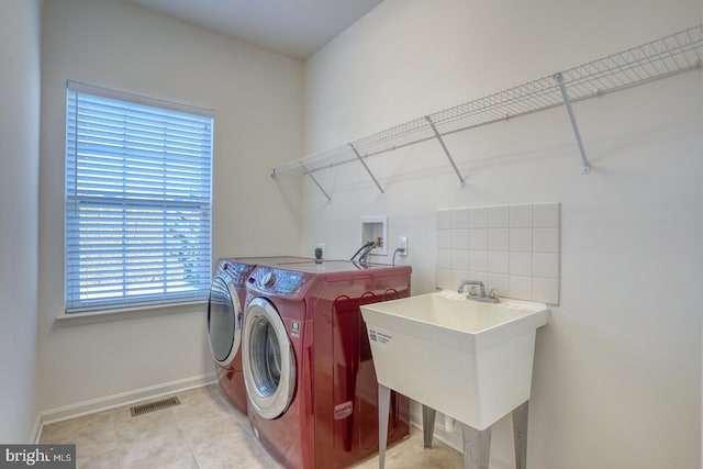 clothes washing area featuring sink and washing machine and clothes dryer