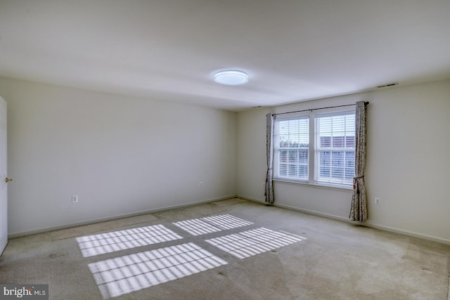 spare room featuring light colored carpet