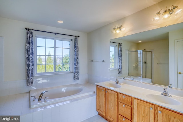 bathroom featuring tile patterned flooring, shower with separate bathtub, vanity, and a healthy amount of sunlight