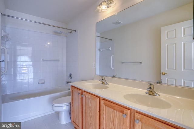 full bathroom featuring tile patterned flooring, tiled shower / bath combo, toilet, and vanity