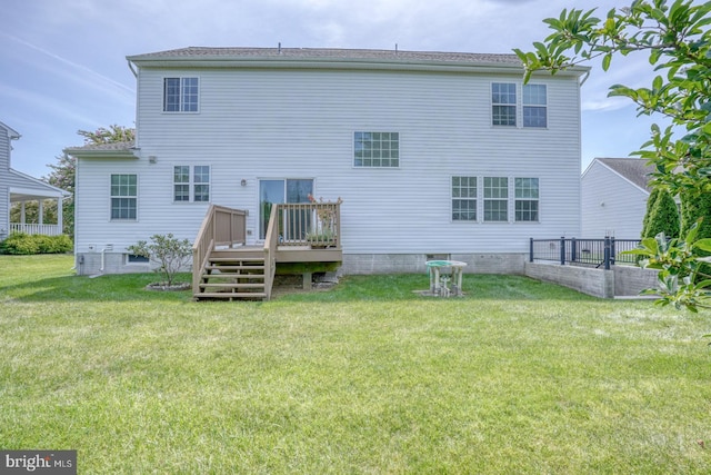 back of house with a lawn and a wooden deck