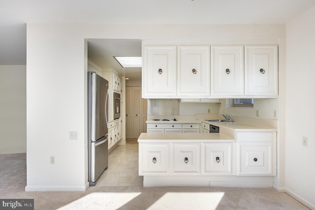 kitchen featuring sink, white cabinets, stainless steel fridge, light colored carpet, and kitchen peninsula