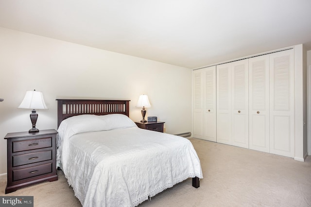 carpeted bedroom with a baseboard radiator and a closet