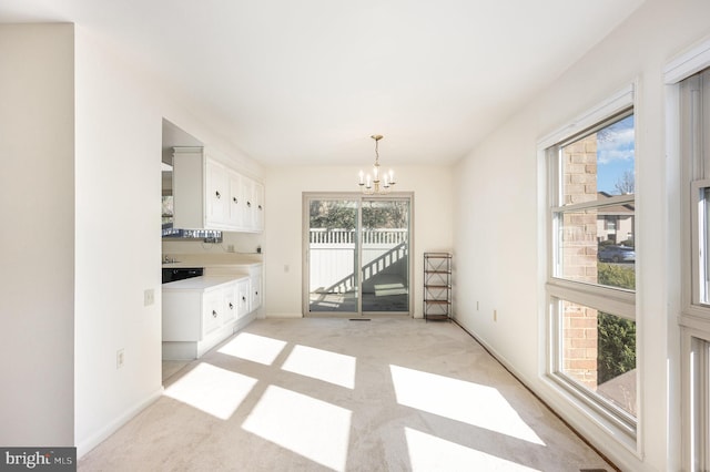 unfurnished dining area with light colored carpet and a chandelier