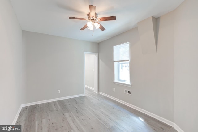 empty room with ceiling fan and light hardwood / wood-style flooring