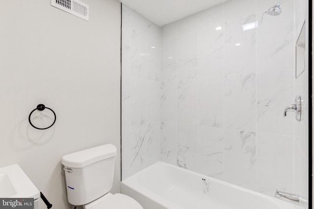 full bathroom featuring vanity, tiled shower / bath combo, and toilet