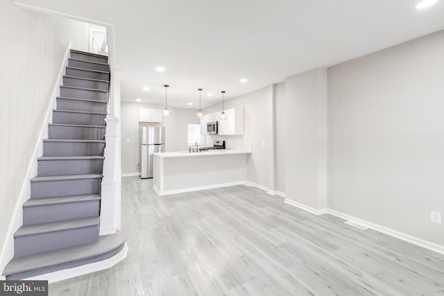 unfurnished living room featuring light wood-type flooring and sink