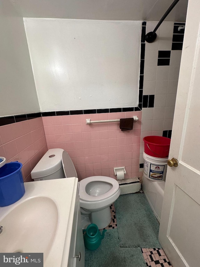 bathroom with tile patterned floors, vanity, toilet, and tile walls