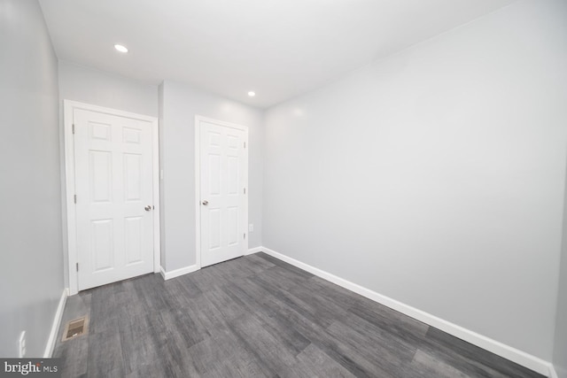 unfurnished bedroom with dark hardwood / wood-style floors