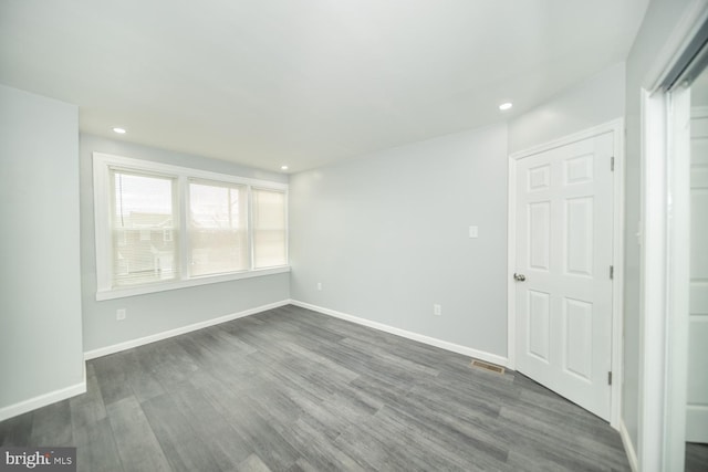 spare room with dark wood-type flooring