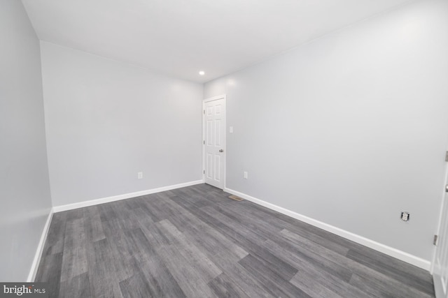 unfurnished room with dark wood-type flooring