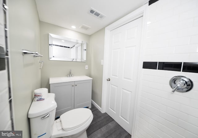 bathroom with hardwood / wood-style floors, vanity, and toilet