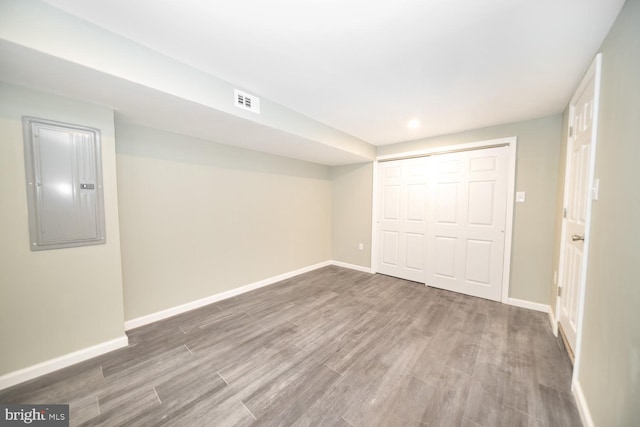 basement featuring electric panel and hardwood / wood-style floors