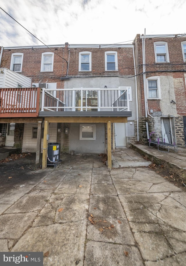 rear view of property featuring a deck and central AC unit