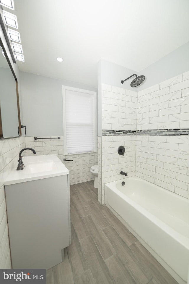 full bathroom with vanity, toilet, and tiled shower / bath