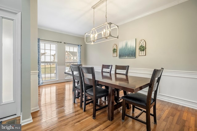 dining room with a notable chandelier, hardwood / wood-style flooring, and ornamental molding